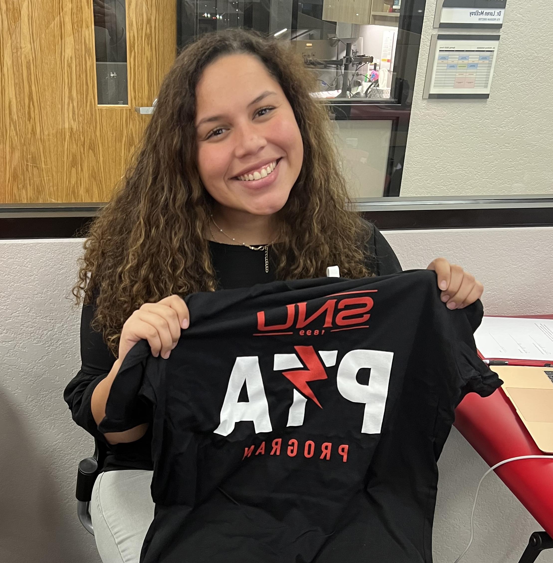 Talea Powell holding shirt from SNU's PTA (Physical Therapist Assistant) program